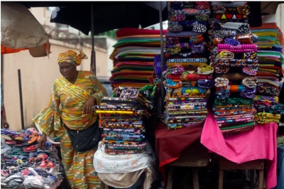 A woman sells fabrics at Kaporo market in Conakry, Guinea Monday, September 13, 2021 [Sunday Alamba/AP Photo]